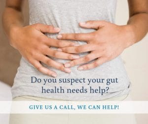 woman holding her gut because of gut issues causing stomach pain, constipation, diarrhea, bloating, gas, heartburn and nausea